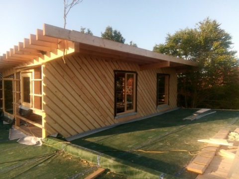 schuine houten planken als gevelafwerking voor woning gebouwd met duurzame materialen