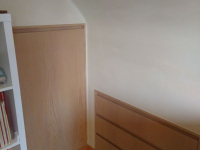 slaapkamer onder dak met houten vloer, ingemaakte kasten en leem + kleifinish